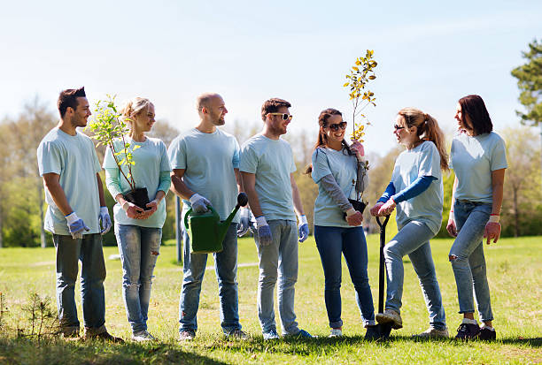 istock group of volunteers with trees and rake in park 607912612