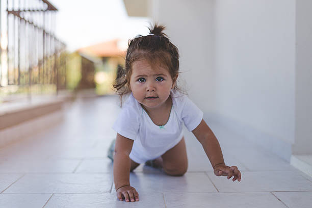 portrait of a baby girl on a terrace hallway - baby tile crawling tiled floor imagens e fotografias de stock