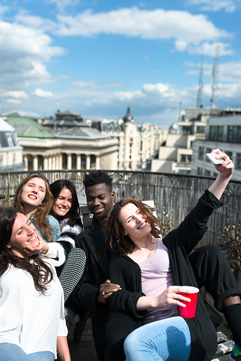 group of friends take a selfie on the rooftop in paris