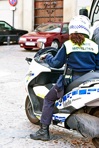 Toledo, Spain - Police in action Toledo, Spain - April 5, 2010: Policewoman in action on a motorbike in the center city in Toledo police policewoman women spain stock pictures, royalty-free photos & images