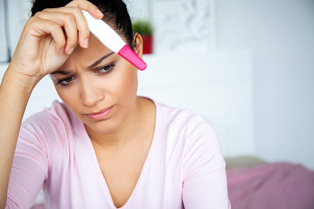 istock worried young woman with pregnancy test 607915106