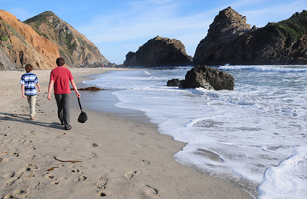 Boys walking along scenic Pfeiffer Beach, California