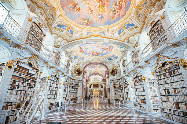 Library Admont Abbey, Austria Admont, Austria - December 4, 2015: Interior of Admont Abbey Library, part of Benedictine monastery in Styria, Austria. The library of Admont Abbey is one of the largest all-embracing creations of the late European Baroque, where many artistic genre epresented through architecture, frescoes, sptures, manuscripts and printed works. The library holds around 70,000 volumes while the Abbey in total owns nearly 200,000 books. Admont Abbey is situated in Styria, in the valley under Alps mountains.  abbey stock pictures, royalty-free photos & images