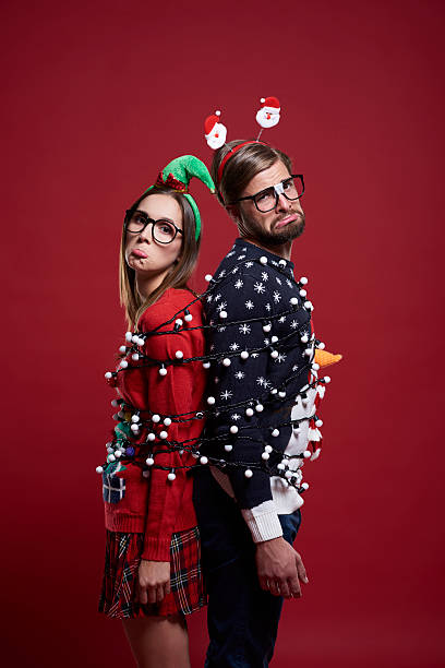 Clumsy couple has problems with Christmas lights Clumsy couple has problems with Christmas lights christmas nerd sweater cardigan stock pictures, royalty-free photos & images