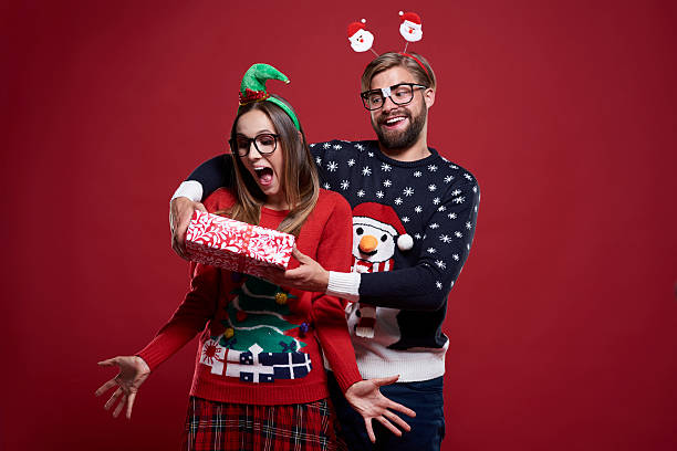 Funny man giving the Christmas gift Funny man giving the Christmas gift christmas nerd sweater cardigan stock pictures, royalty-free photos & images