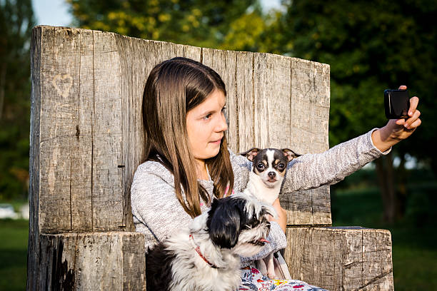 istock Girl taking selfie with her two dogs (Shih Tzu, Chihuahua) 607919802