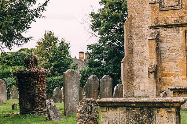 pierres tombales dans le cimetière - cemetery crossing green grass photos et images de collection