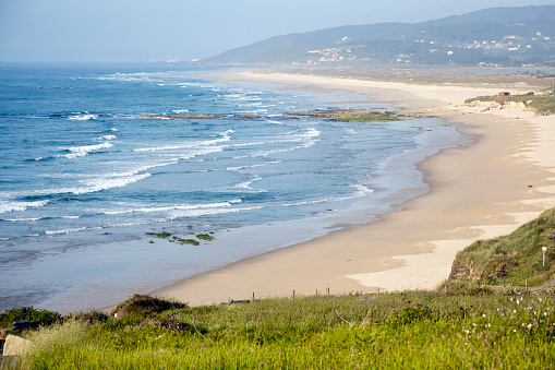 Beautiful large Razo beach, Carballo, A Coruña, Galicia, Spain, view from above, green field in the foreground.