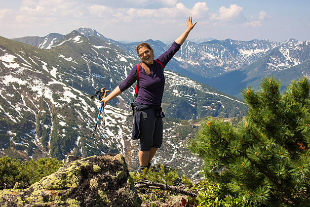 istock girl celebrates victory in the mountains 607923246