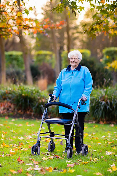 istock Senior lady with a walker in sunny autumn park 607925104