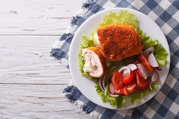 chicken schnitzel cordon bleu and a salad. horizontal top view - schnitzel cutlet food meal imagens e fotografias de stock