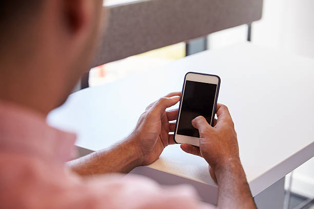 istock View Over The Shoulder Of Male Student Using Mobile Phone 607928486