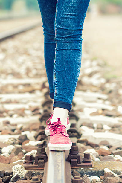 istock female legs on the rail 607928910