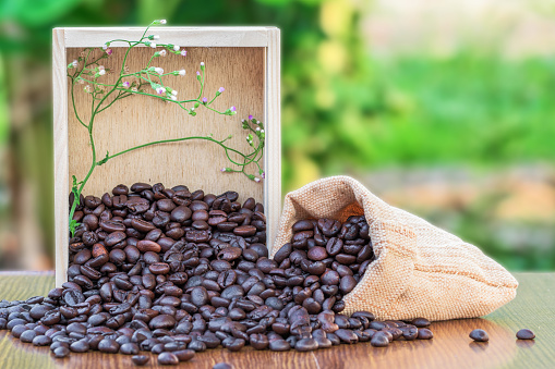 Coffee in wooden box on wood table with green blurred background