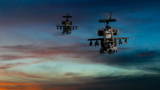 Military gunship helicopters flying with dramatic sky in background