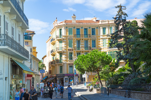 Cannes, France - September 19, 2016: Cannes. Old city street with town houses and people walking via the street