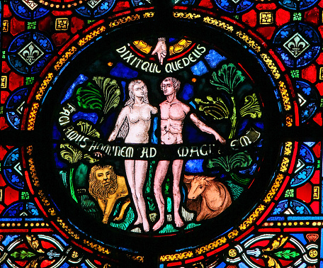 Dinant, Belgium - October 16, 2011: Creation of Adam and Eve, stained glass window in the church of Dinant, Belgium.