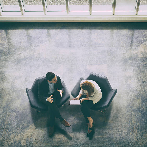 над головой на два деловых людей в вестибюле - talking chair two people sitting стоковые фото и изображения