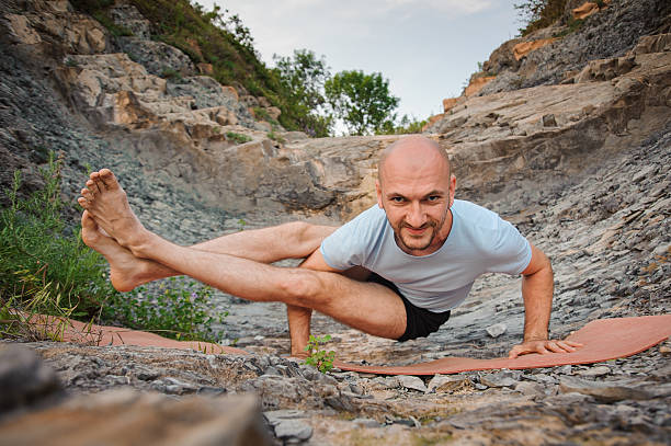 istock Young man doing an ashtavakrasana. Hand standing 607980142