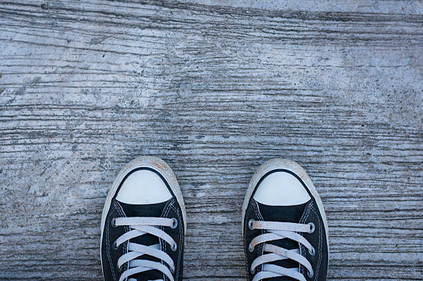 istock Black sneakers with hipster man on concrete 607980358