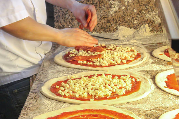 istock Chef putting salami above pizza dough 607983862