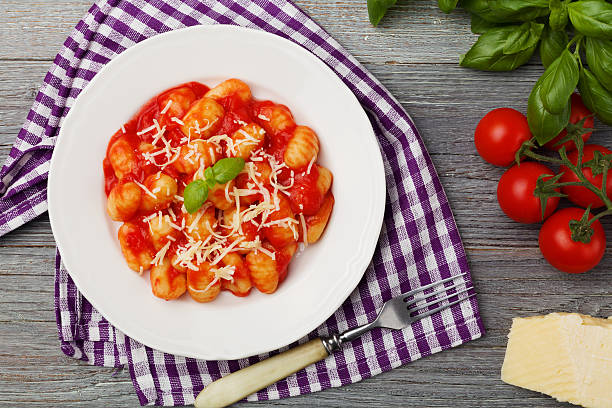 Portion of gnocchi in tomato sauce with cheese.