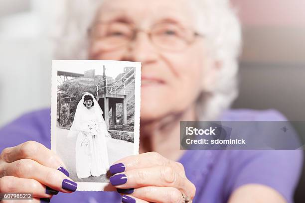 Senior Woman Holding Her Wedding Photo Stock Photo - Download Image Now - Senior Adult, Wedding, Memories