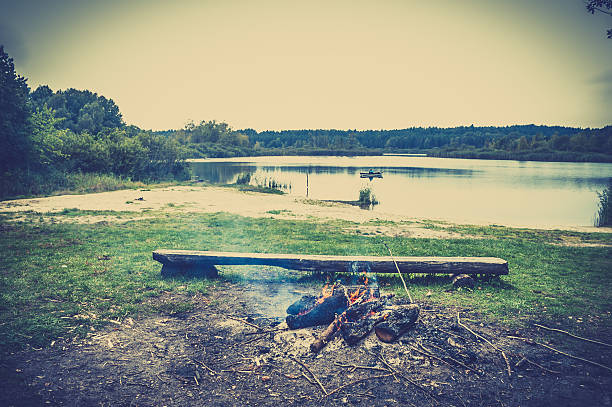 istock Rustic bonfire over lake. Burning logs of wood. 607988022