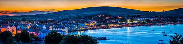seaside resort town ocean bay illuminated at sunset swanage dorset - swanage imagens e fotografias de stock