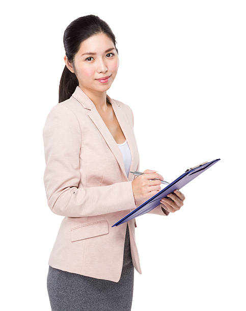 istock Businesswoman writing on clipboard 607989960