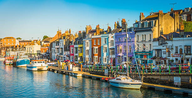 coloridas cabañas de pesca junto al puerto turístico turistas pubs panorama dorset - english pub fotografías e imágenes de stock
