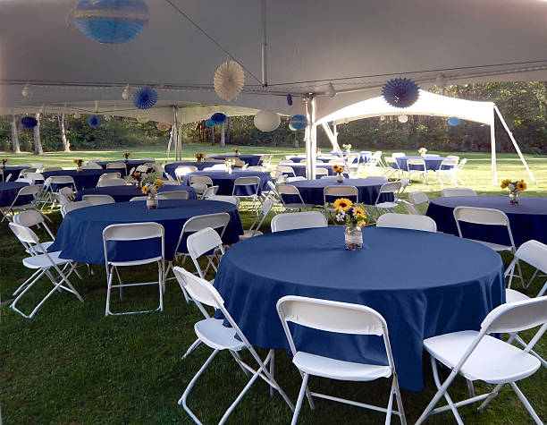 Garden party setup with tables, chairs, tents.  Blue.  White. stock photo