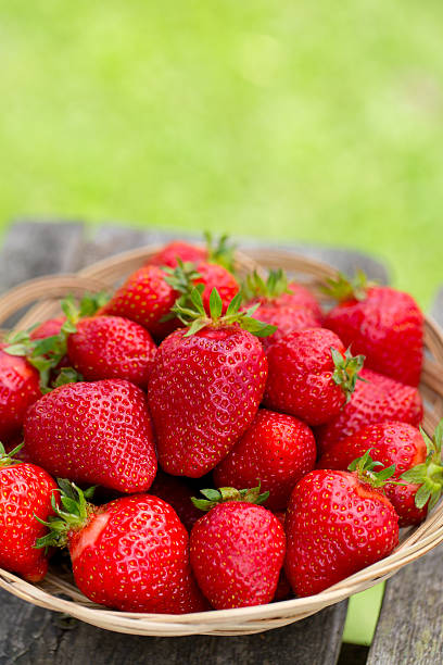 istock basket with strawberries on a garden wooden table 607990758