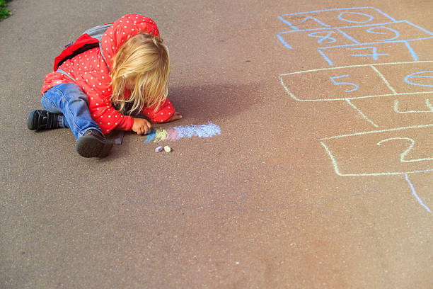 istock little girl drawing on asphalt after school 607991316