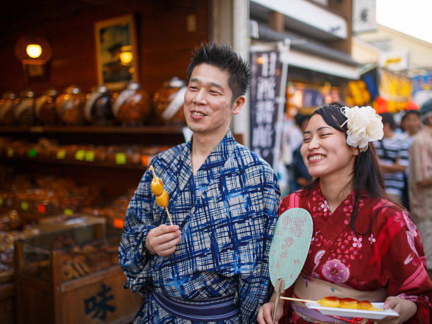 istock Japanese Yukata couple eating dango on street 607991394