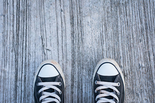 istock Black sneakers with hipster man on concrete 607992086