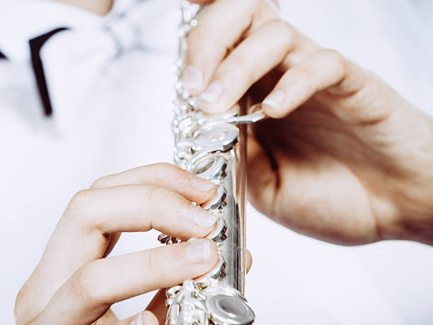 istock Hands of young man playing the flute 607992386