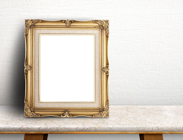 istock Blank Gold victorian picture frame on cream marble table 607992424
