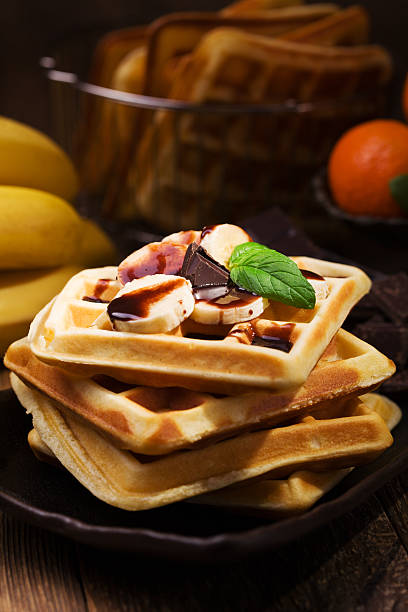 istock Delicious waffles with banana and chocolate 607992558