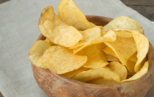 istock Delicious crispy potato chips in an old wooden bowl 607995372