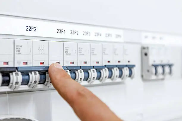 Hand, finger is pushing for activation or shutdown automatic fuse breaker in modern control system at residential place.