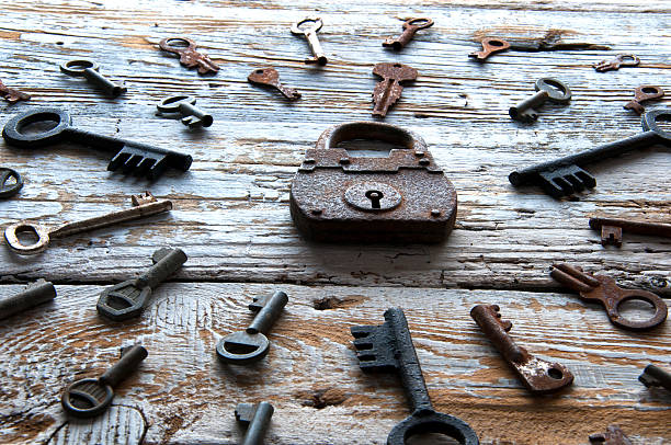 istock Old rusty padlock and keys on white wooden table 607997140
