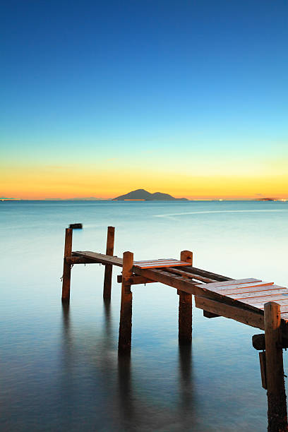 istock Seascape with sunset and wooden bridge 607998348
