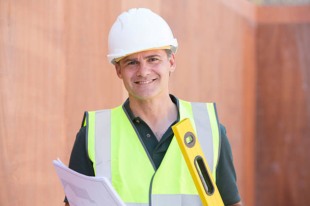 Portrait Of Construction Worker On Building Site With House Plan Portrait Of Construction Worker On Building Site With House Plans basement construction site construction blueprint stock pictures, royalty-free photos & images