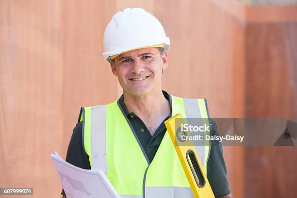 Portrait Of Construction Worker On Building Site With House Plan Stock Photo - Download Image Now