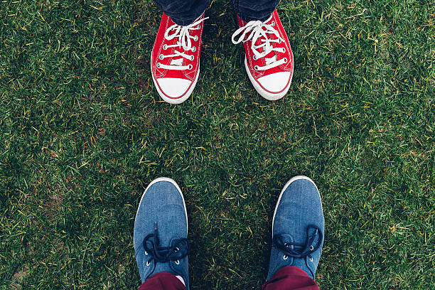 istock youth sneakers on legs and grass during sunny summer day 607999286