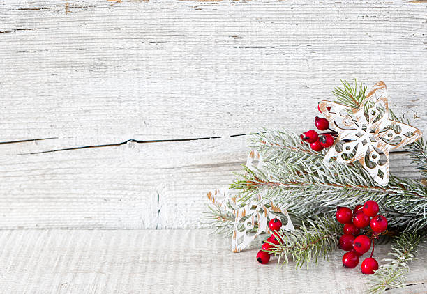 istock Fir branch with Christmas decorations on  white rustic wooden background. 608001404