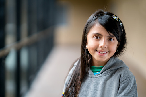 Portrait of a Latin American girl at school looking at the camera smiling - education concepts