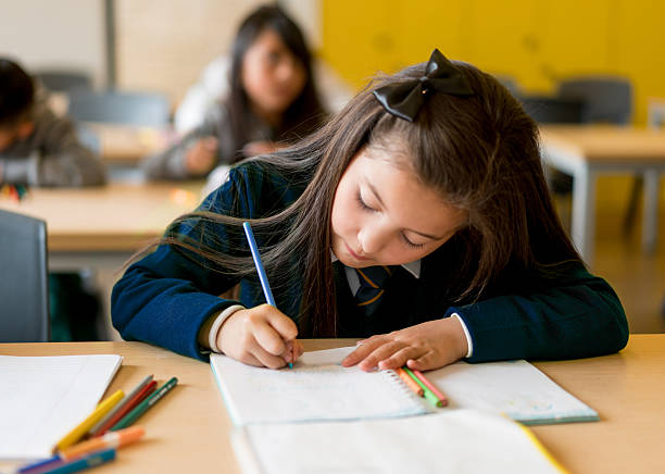 istock Girl at the school drawing on her notebook 608003132