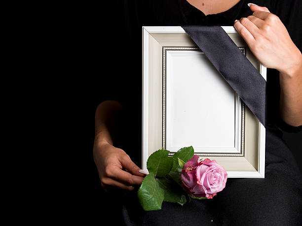 istock woman holds blank mourning frame, with flower 608004292